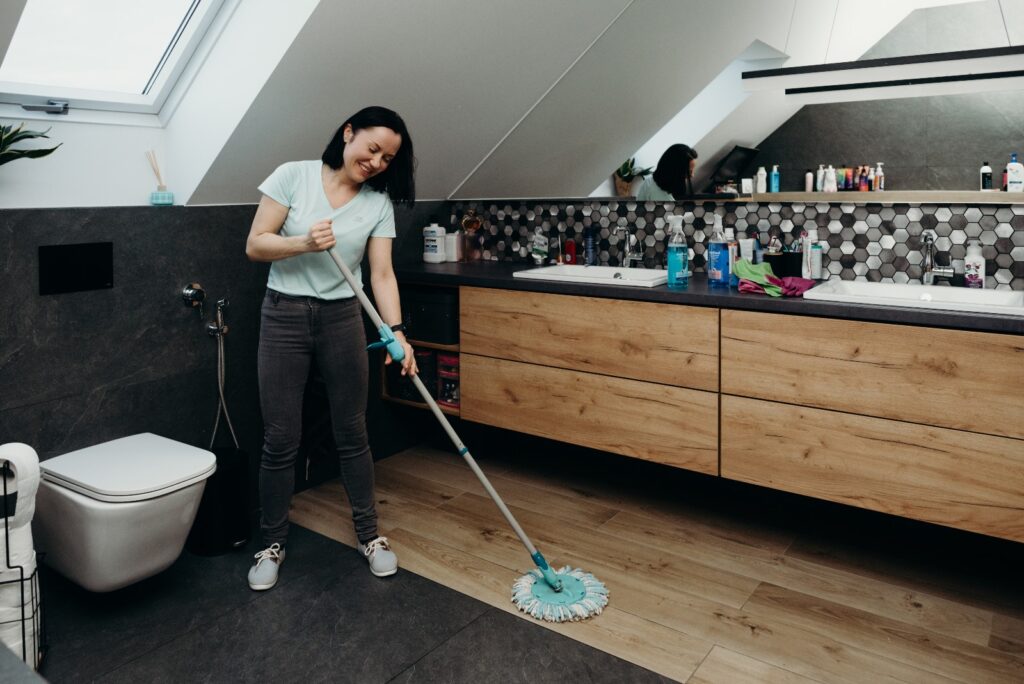 Woman mopping the floor in a bathroom